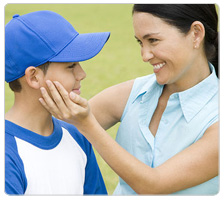 A mom congratulates her son at a baseball game.